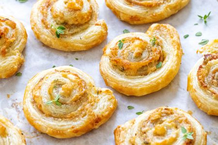 Prosciutto puff pastry spirals on a baking sheet