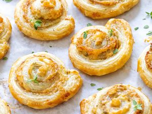 Prosciutto puff pastry spirals on a baking sheet