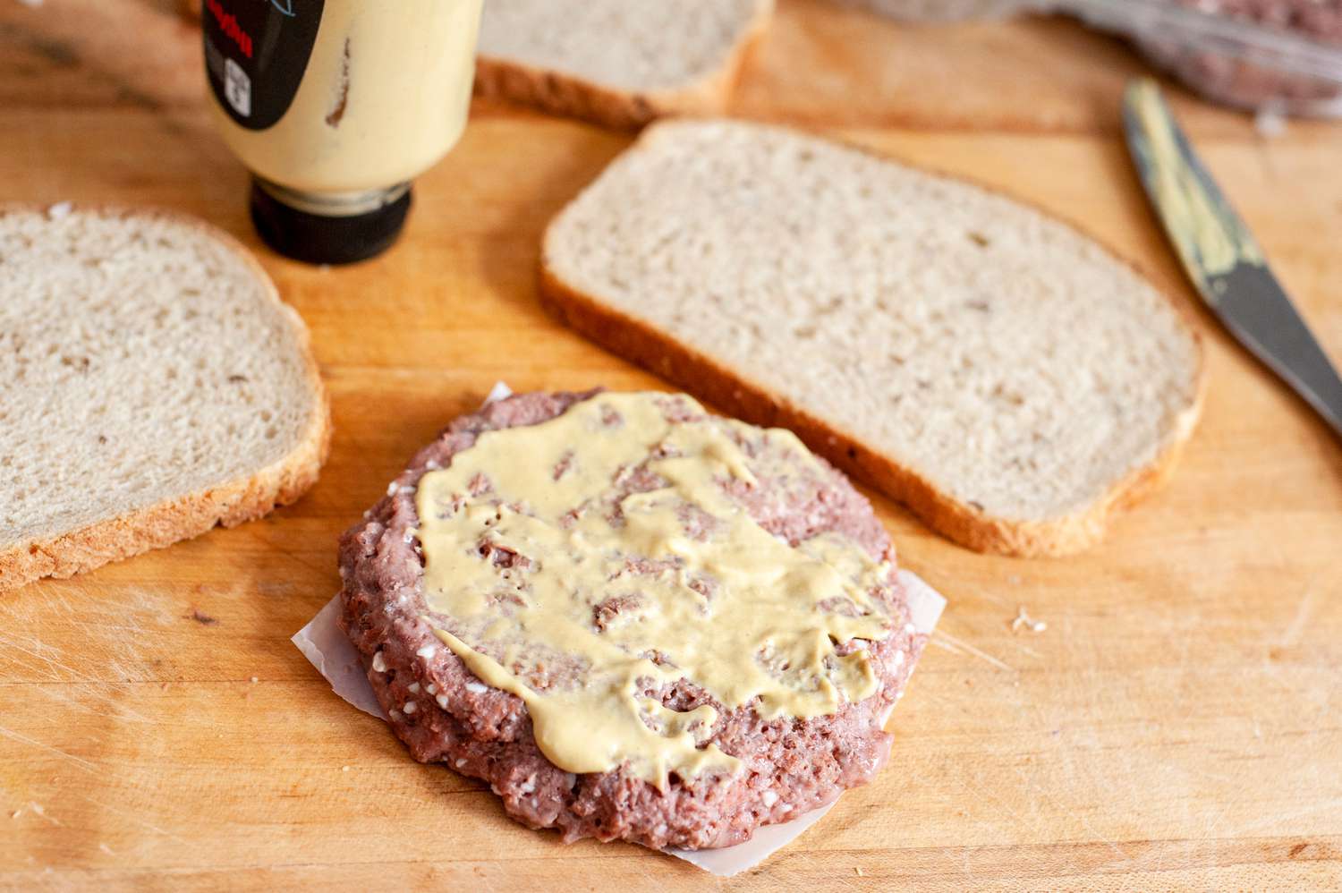 Dijon Mustard Added to Impossible Burger Patty, and Next to It, Two Pieces of Rye Bread for Vegan Patty Melt