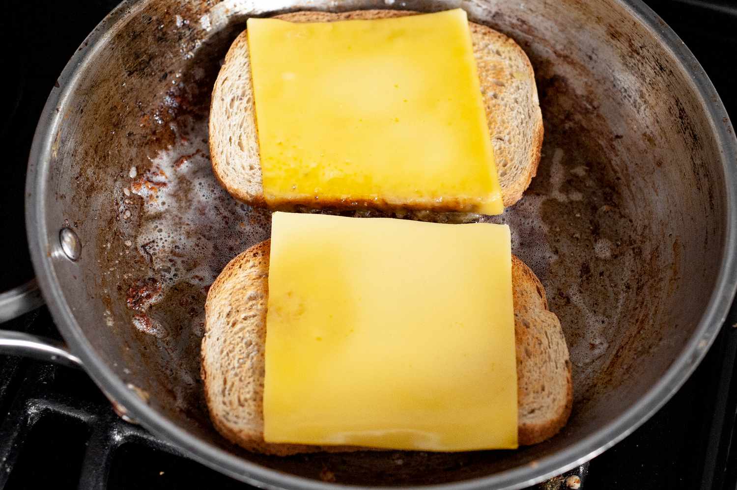 Rye Bread Slices Topped with Vegan Cheese on a Heated Skillet for Vegan Patty Melt Recipe