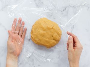 Dough for Peanut Butter Cookies being wrapped in plastic wrap.