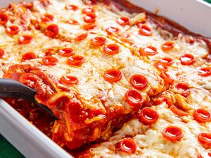 Spatula Slightly Lifting a Slice of Pepperoni Pizza Lasagna From a Casserole Dish With the Rest of the Lasagna