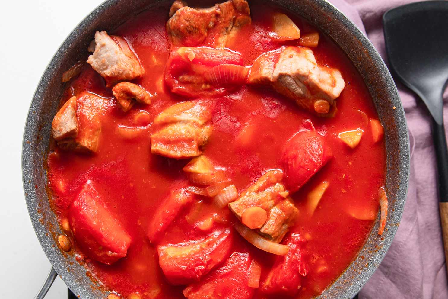 Boiled Pork, Carrots, Tomato Paste, Potatoes, Onions, Tomatoes, and Tomato Sauce Mixed Together in the Pot for Pork Asado de Carajay Recipe