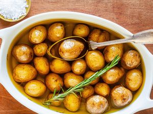 Potato confit in white casserole dish.