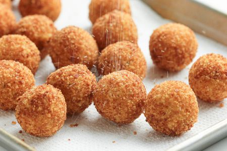 Potato Croquettes Sprinkled with Salt, All Sitting on a Paper Towel Lined Baking Pan
