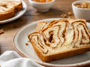 Slices of Povitica on a Plate Surrounded by Small Bowls of Ingredients (Pecans, Cinnamon, etc)