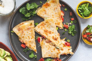 A plate of quesedillas and toppings.