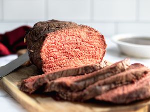 A sliced roast beef cooked to medium rare beef temperature.