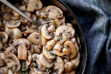 sautéed mushroom in black bowl scooped with spoon