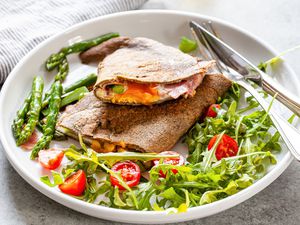 Buckwheat Crepes with Egg, Ham, Cheese, and Asparagus and a Side Salad on a Plate