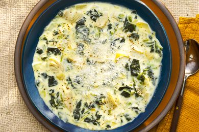 Overhead view of a bowl of spinach artichoke dip soup