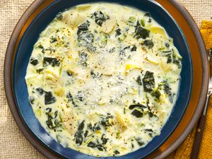 Overhead view of a bowl of spinach artichoke dip soup