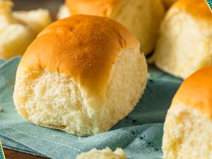 Photo of dinner rolls on a tea towel with fun line illustrations on the edges of the photo 