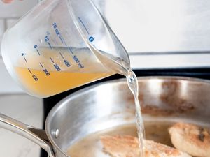 Stock Poured from the Measuring Cup into a Pan on the Stove 