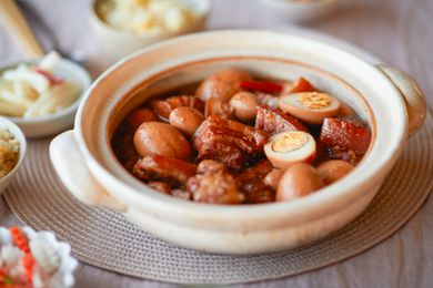 Pork belly and eggs braised in sweet coconut water in a bowl.