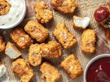 Vegan Chicken Nuggets Sprinkled with Salt Flakes on a Newspaper with Two Bowls of Sauces 