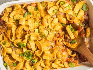 Walking taco casserole in a casserole dish with a spoon (casserole dish missing some casserole / some of the casserole was already served)