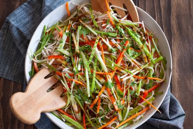 Overhead view of an easy rice noodle salad in a serving bowl along with wooden claws.