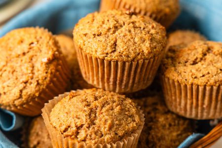 Bran muffins in a table napkin lined basket