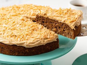 Coffee Coconut Banana Bread Cake on a Cake Platter With a Cut Slice Lifted Using a Pie Server