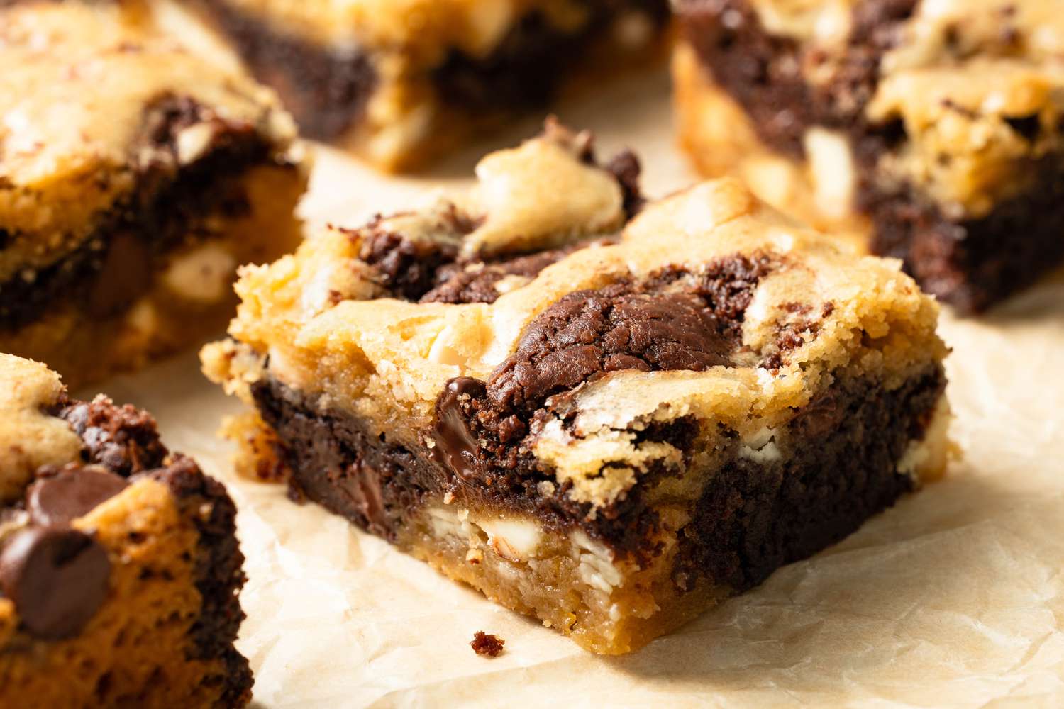 Close-up of one of the marble brownie slices, which is surrounded by more slices of marble brownies, all on a parchment paper lined baking sheet