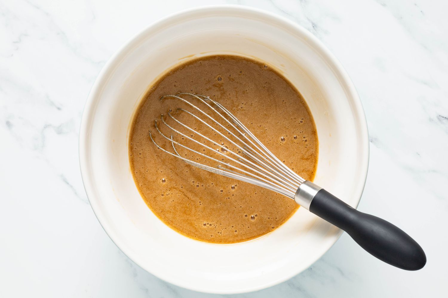 Bowl of wet ingredients whisked together for marble brownies recipe