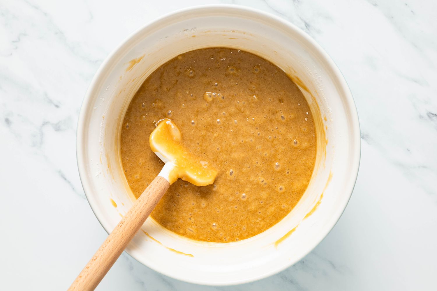 Blondie batter in a bowl with a rubber spatula for marble brownies recipe