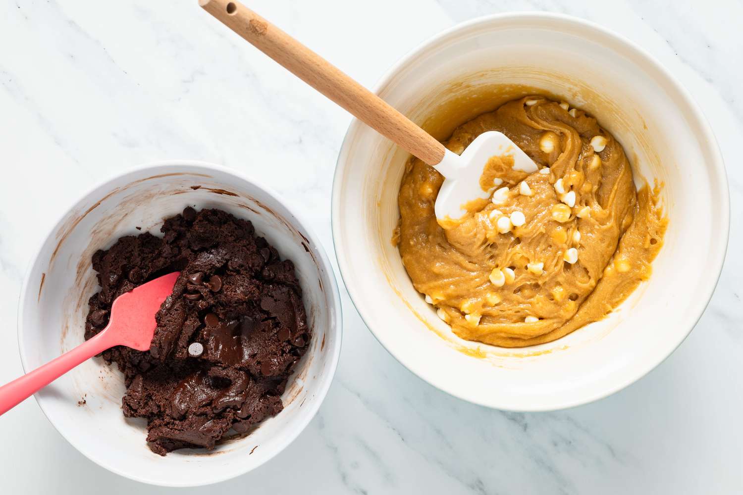 Semi-sweet chocolate chips added to bowl of brownie batter, and white chocolate chips added to bowl with blondie batter for marble brownies recipe