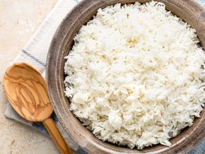 Microwave Rice in a Bowl on a Kitchen Towel with a Wooden Spoon 