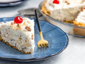 Slice of Million Dollar Pie on a Plate With a Fork, and in the Background, More Pie in a Pie Dish