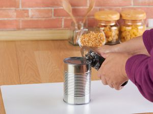 Woman opening a can of corn