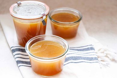 Turkey stock with leftover bones in glass containers.